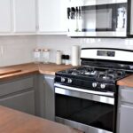 white upper cabinets gray lower cabinets kitchen with stainless appliances