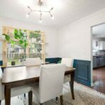 dining room after with teal picture frame moulding and window plant shelves