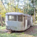 Ruby's Revival exterior - front of unpolished vintage camper in wooded area