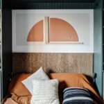 murphy bed nook reveal - exhale rust arch color block art and carved wood headboard with neutral bedding and rust coverlet