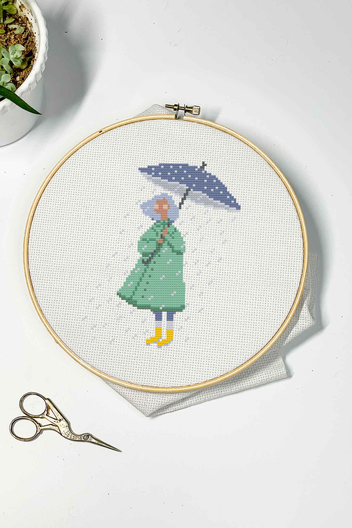 April Showers cross stitch pattern - girl with green raincoat and blue umbrella