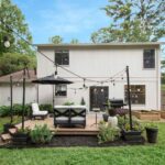 back yard white house paint with floating deck and light pole planters