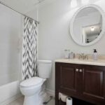 primary bathroom white tile and dark vanity