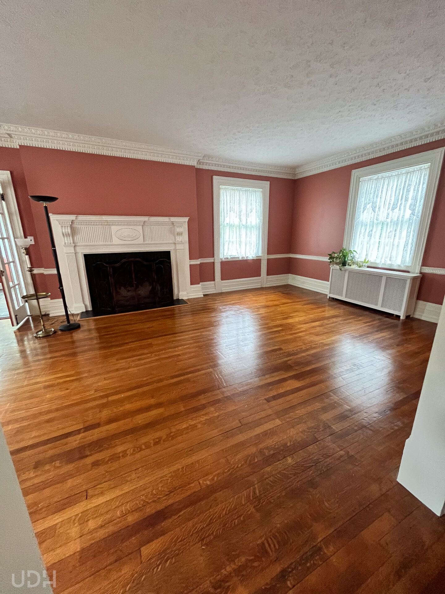 pink living room in a colonial revival house with white fireplace and elaborate moulding
